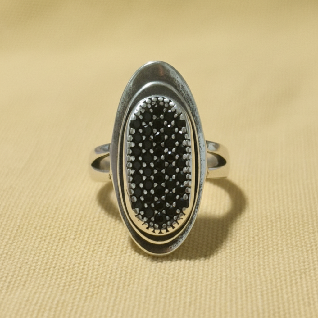 Anillo Espinelas Negras frontal sobre fondo beige