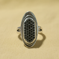 Anillo Espinelas Negras frontal sobre fondo beige