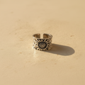 Anillo Girasol con Semillas visto de frente sobre fondo beige cálido, con pétalos y centro detallado