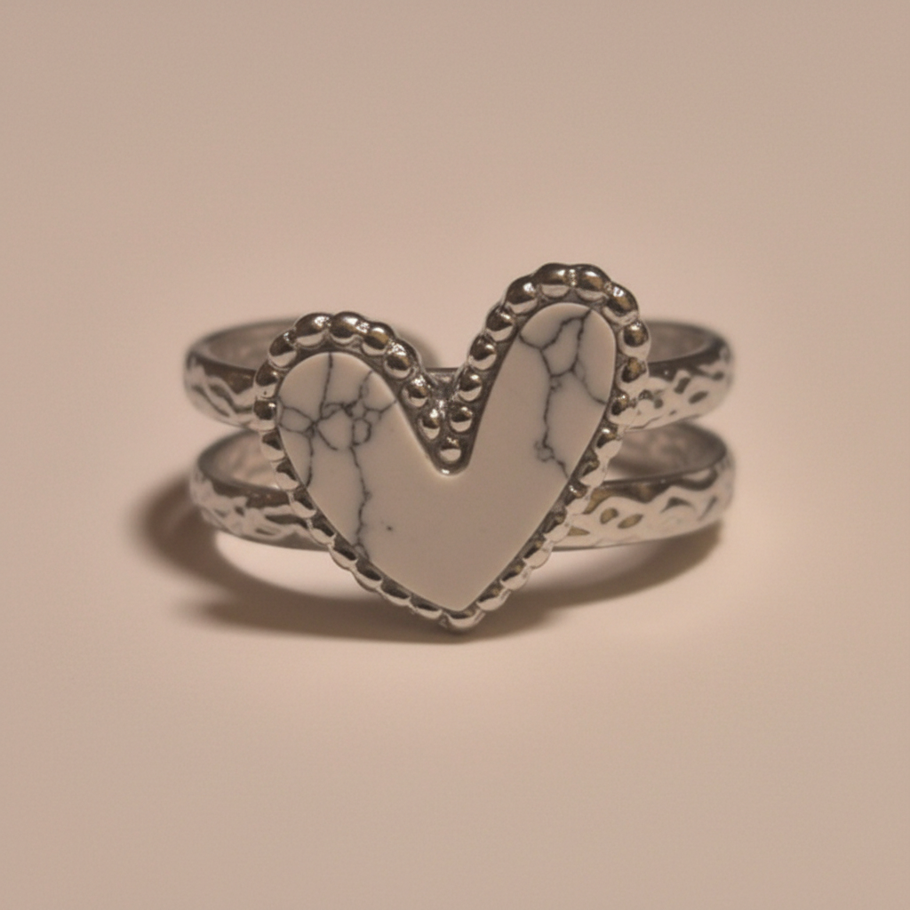 Anillo Turquesa Blanca ajustable de acero con piedra luminosa, visto de frente sobre fondo beige