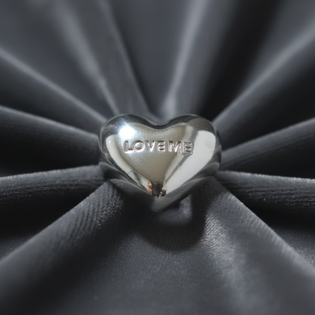 Detalle de la inscripción LOVE ME en un anillo puffy de plata 925