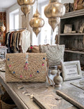 Bolso boho chic clutch con tachuelas plateadas y pompones pastel