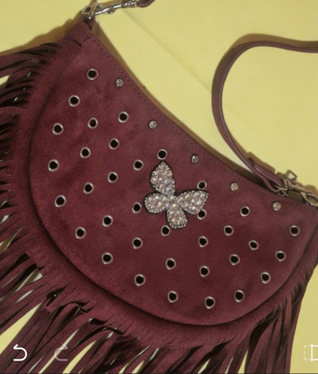 Detalle mariposa brillante bolso boho chic flecos antelina burdeos | vaqueraspain