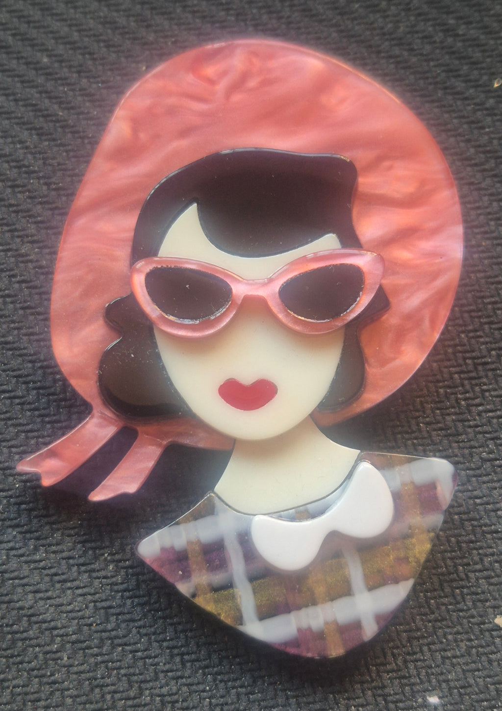 Broche retro de acrilico de busto mujer con gafas de sol rosas.