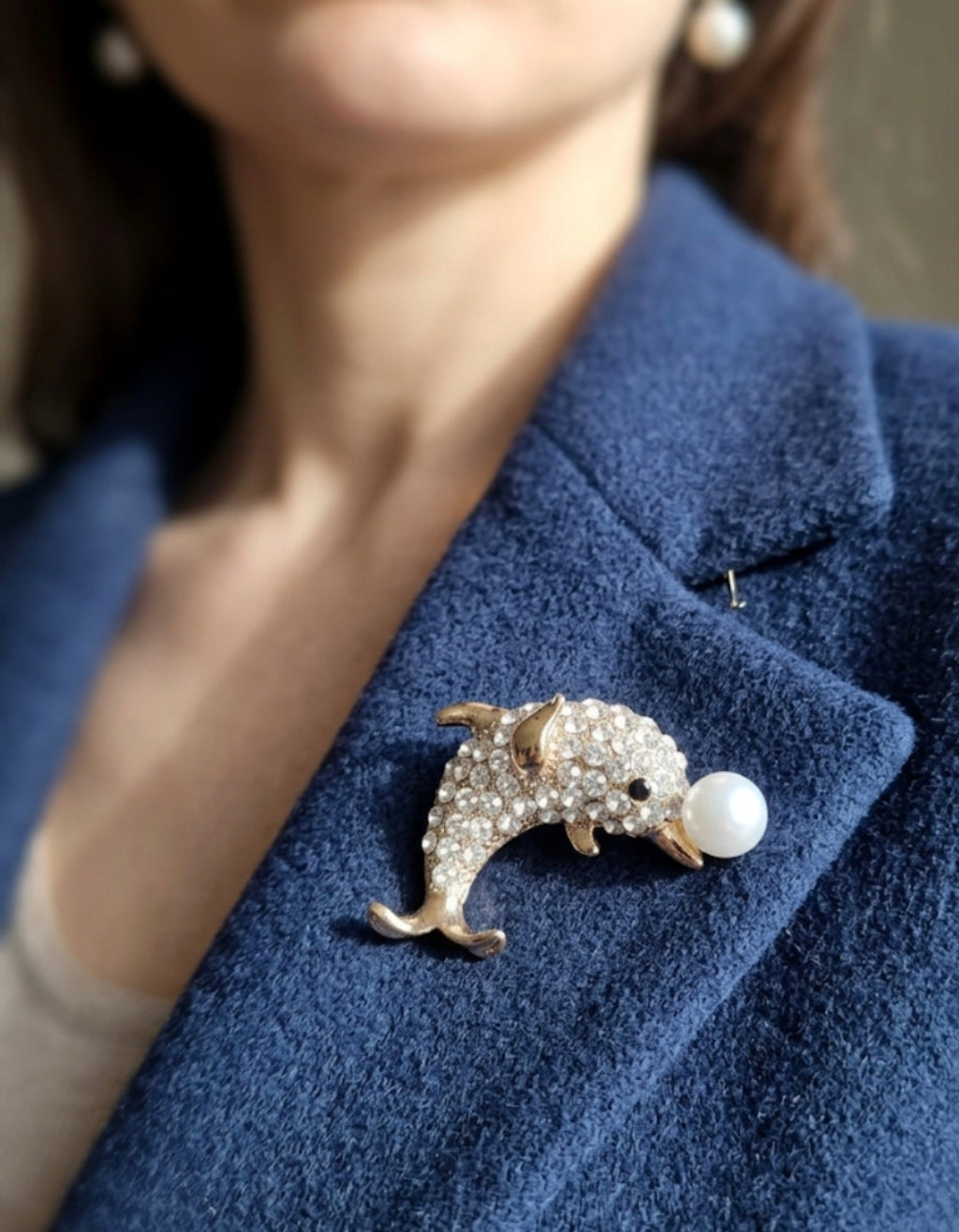 Broche con forma del delfin sosteniendo perla blanca