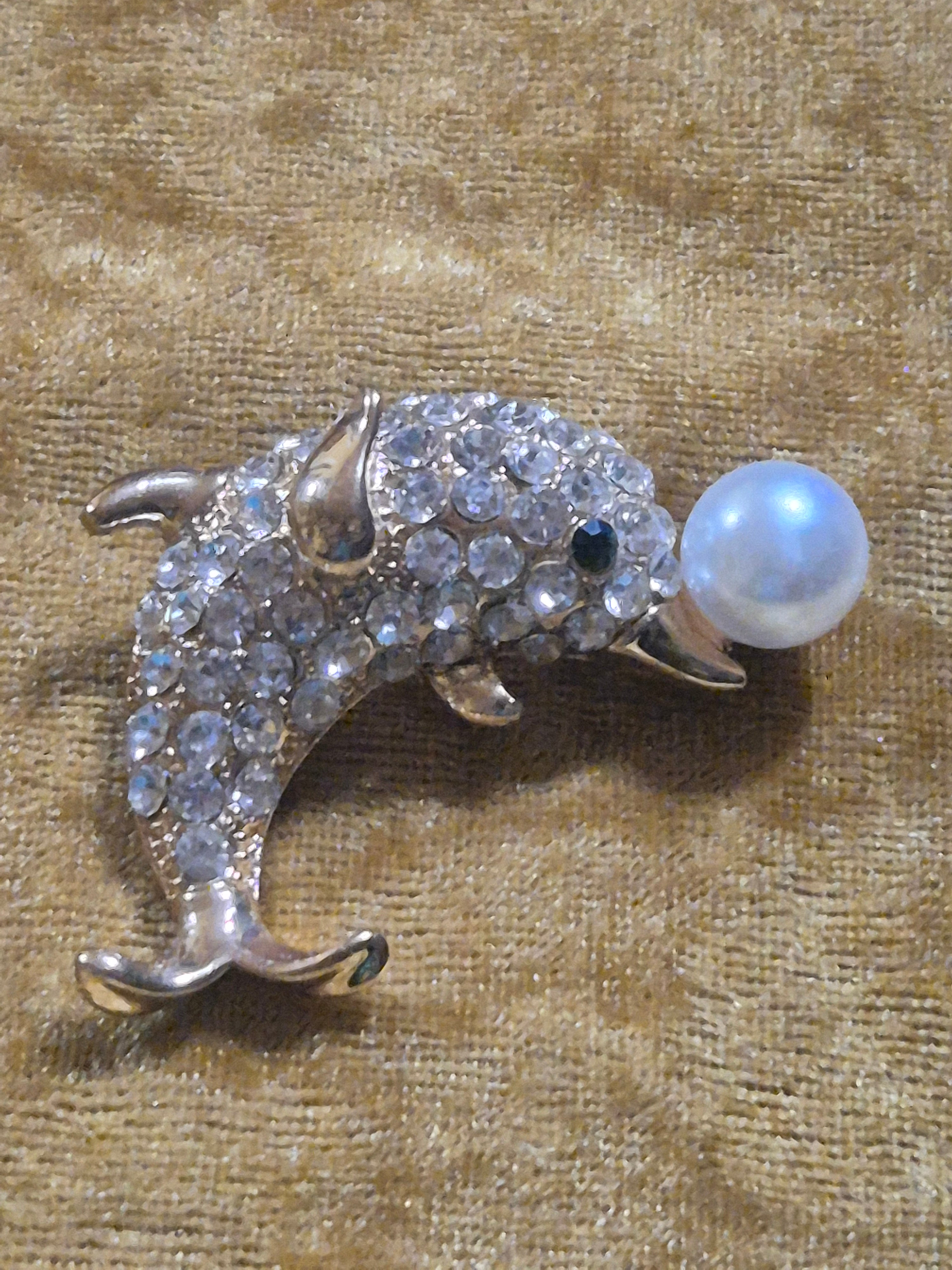 Broche con forma del delfin sosteniendo perla blanca