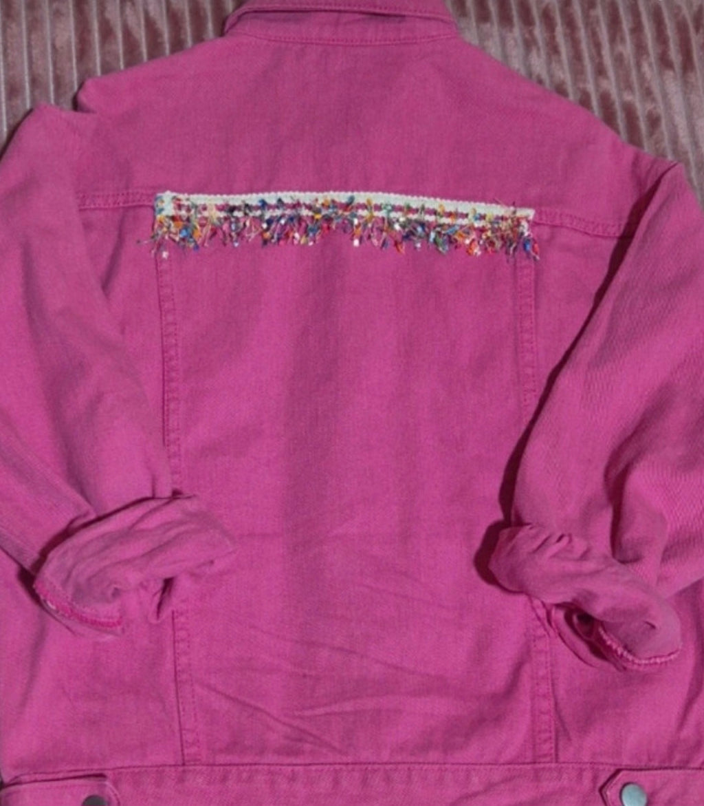 Vista lateral chaqueta denim fucsia artesanal con borlas de colores | vaqueraspain
