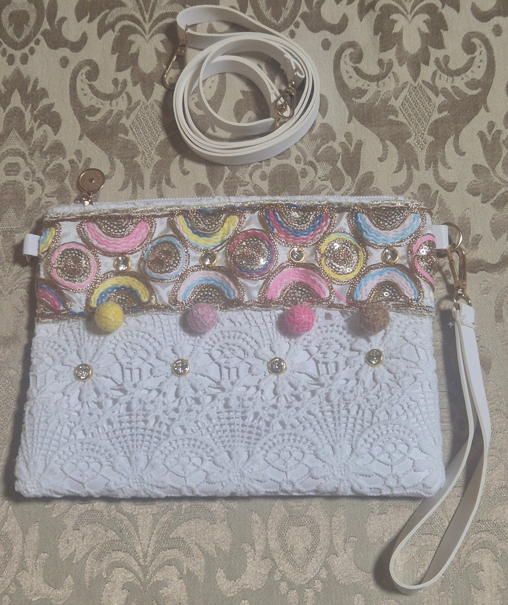 Bolso boho chic con bordados semicírculos coloridos y pompones.