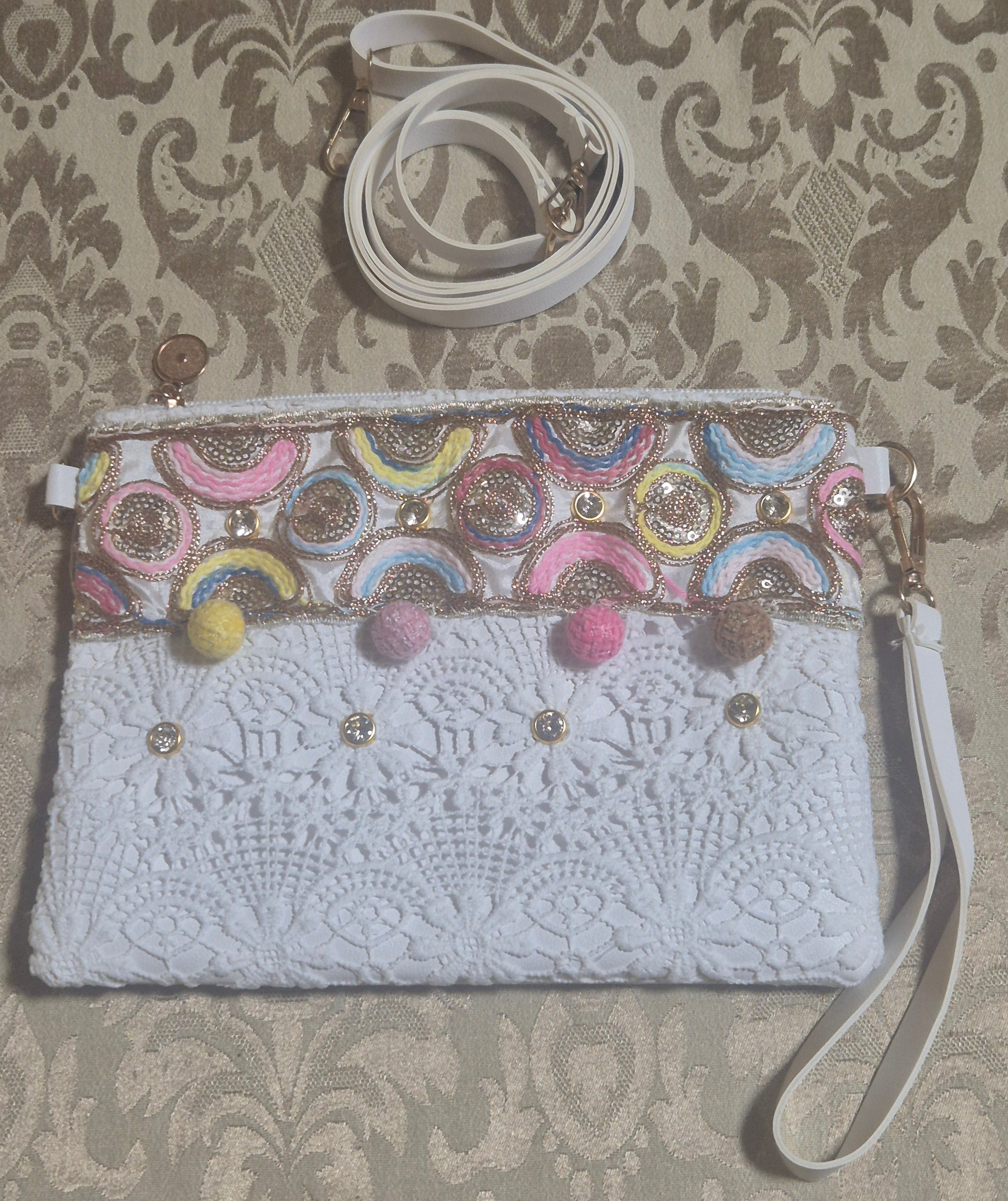 Bolso boho chic con bordados semicírculos coloridos y pompones.