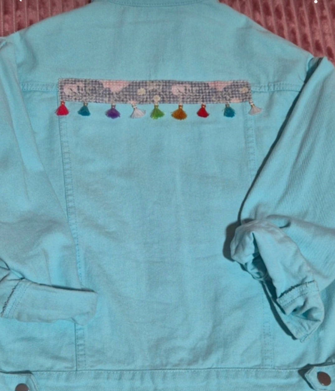 Vista trasera chaqueta vaquera azul pastel con borlas multicolores | vaqueraspain