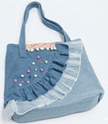Vista lateral bolso tote vaquero bohemio con pompones boho chic | vaqueraspain