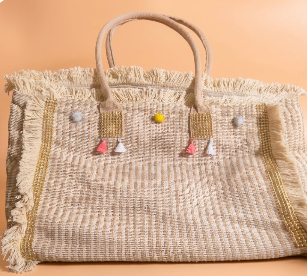Detalle pompones y borlas bolso tote boho beige crema artesanal | vaqueraspain