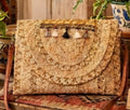 Bolso boho chic con detalles dorados y borlas decorativas.