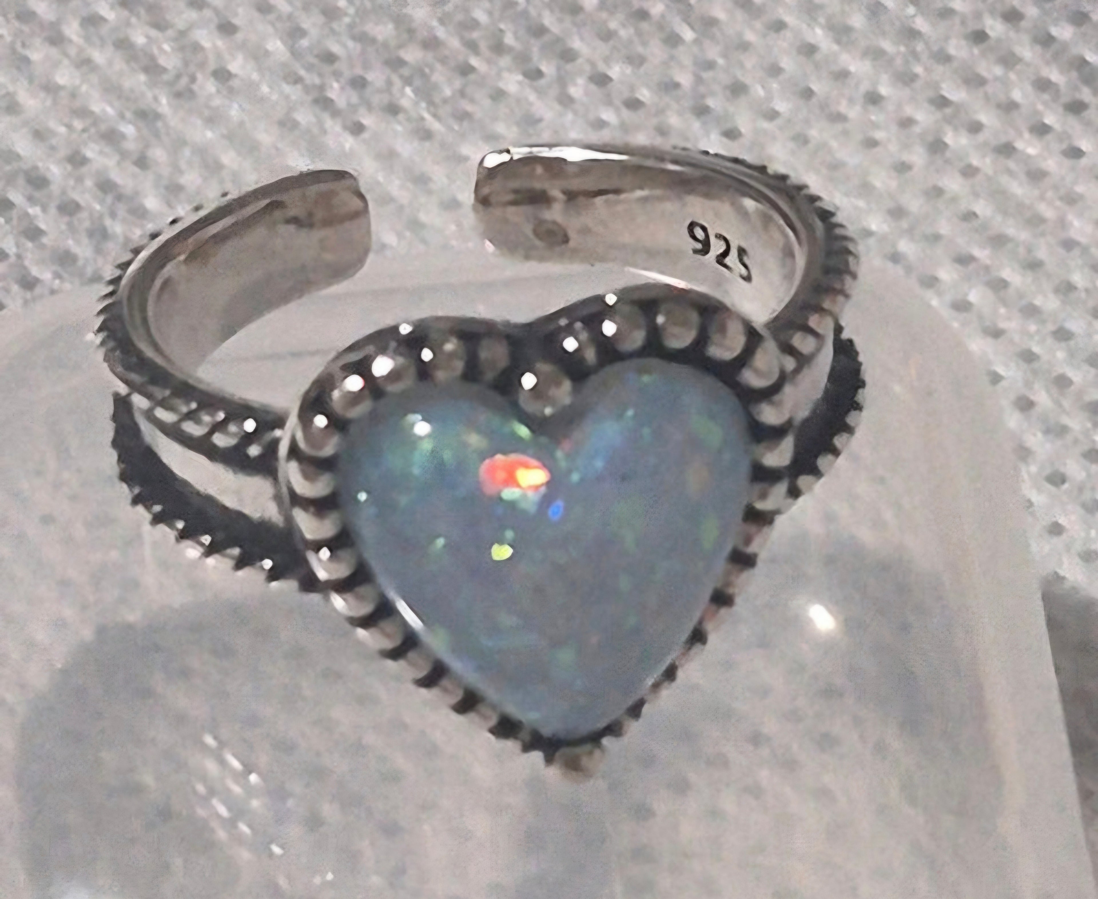 Vista macro detalle ópalo multicolor anillo corazón plata 925 | vaqueraspain