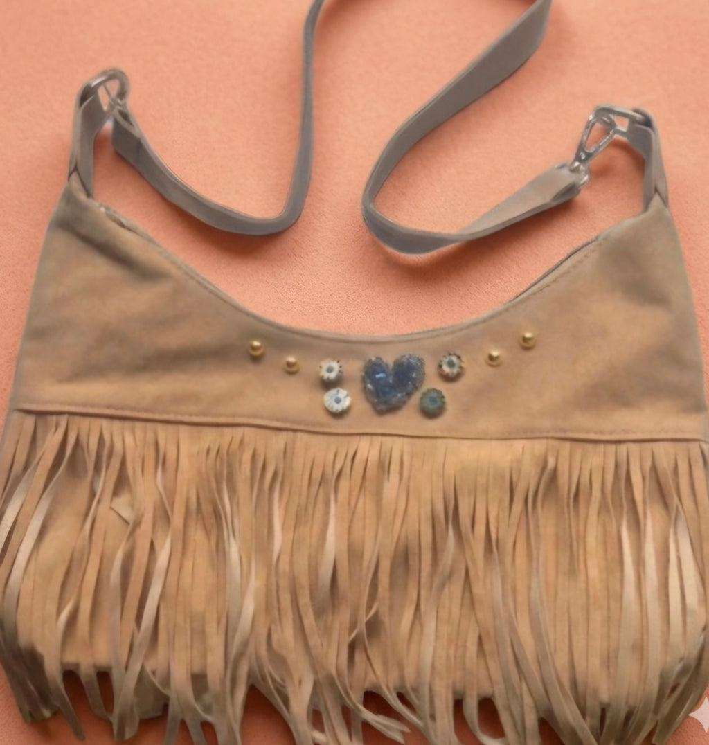 Vista lateral bolso bohemio flecos beige claro con corazón | vaqueraspain