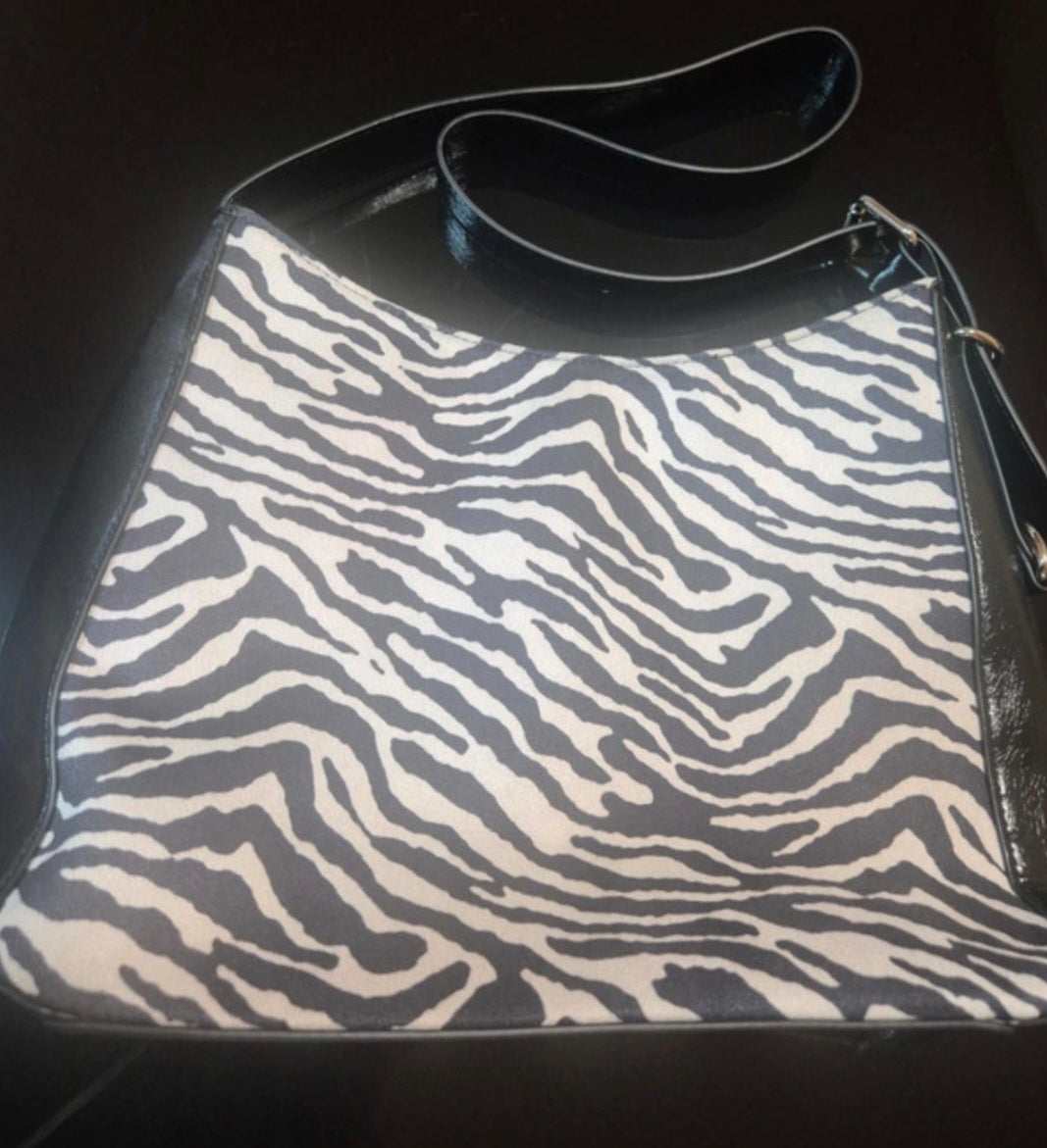 Vista lateral bolso hobo bohemio cebra media luna brillante cuero sintético | vaqueraspain