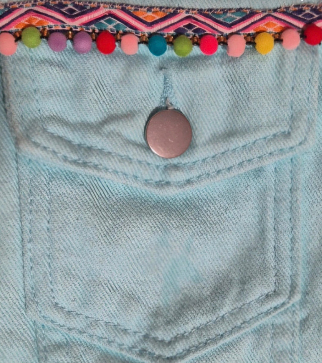 Vista lateral chaqueta denim azul pastel artesanal con borlas boho chic | vaqueraspain