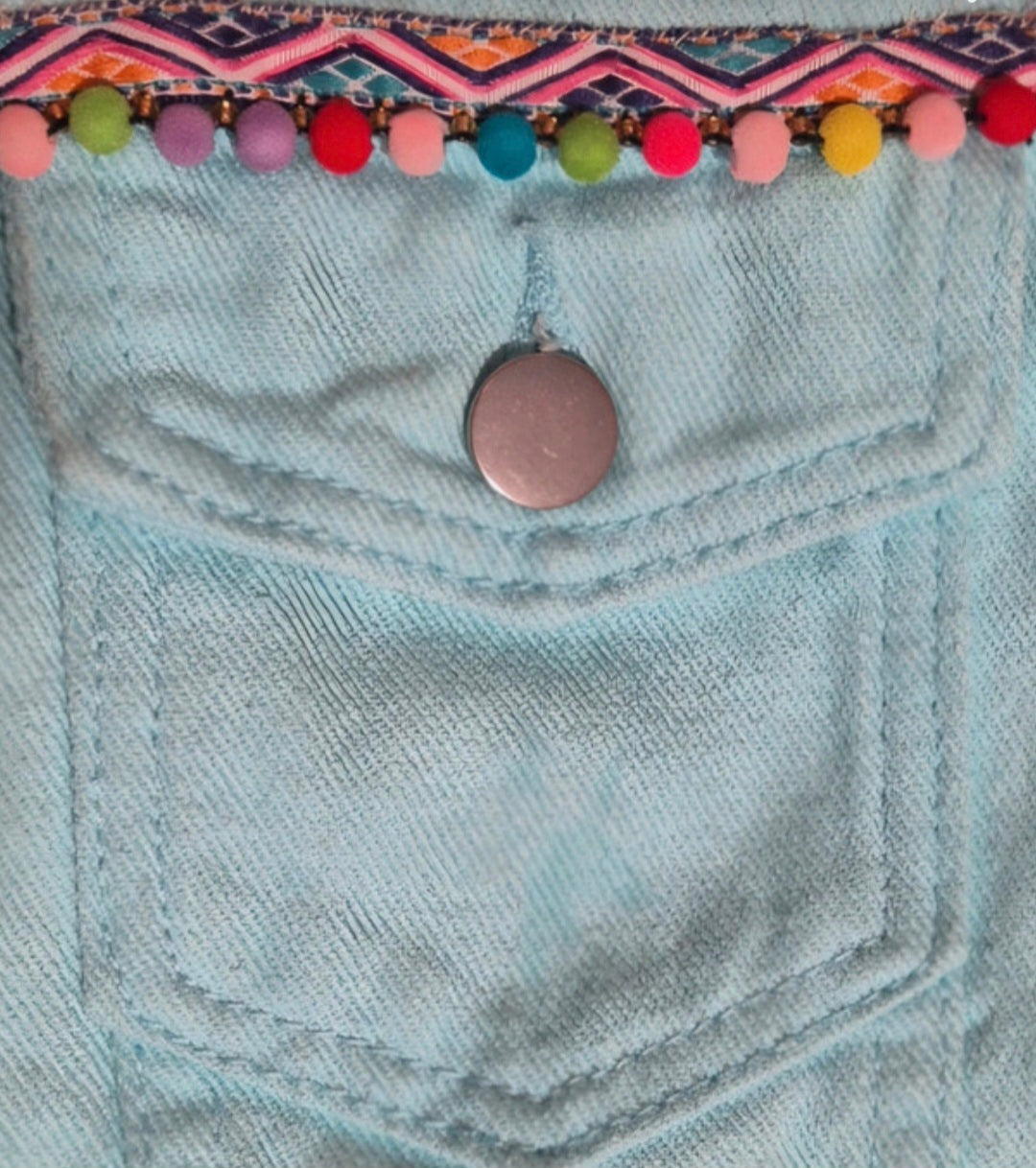 Vista lateral chaqueta denim azul pastel artesanal con borlas boho chic | vaqueraspain