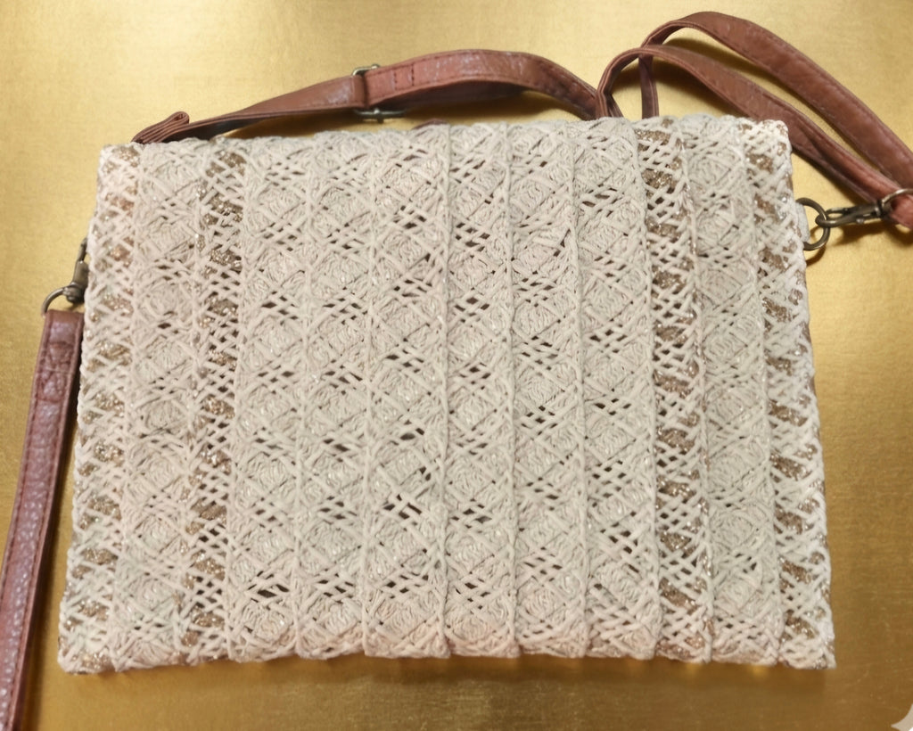 Bolso boho chic con detalles dorados y borlas decorativas.
