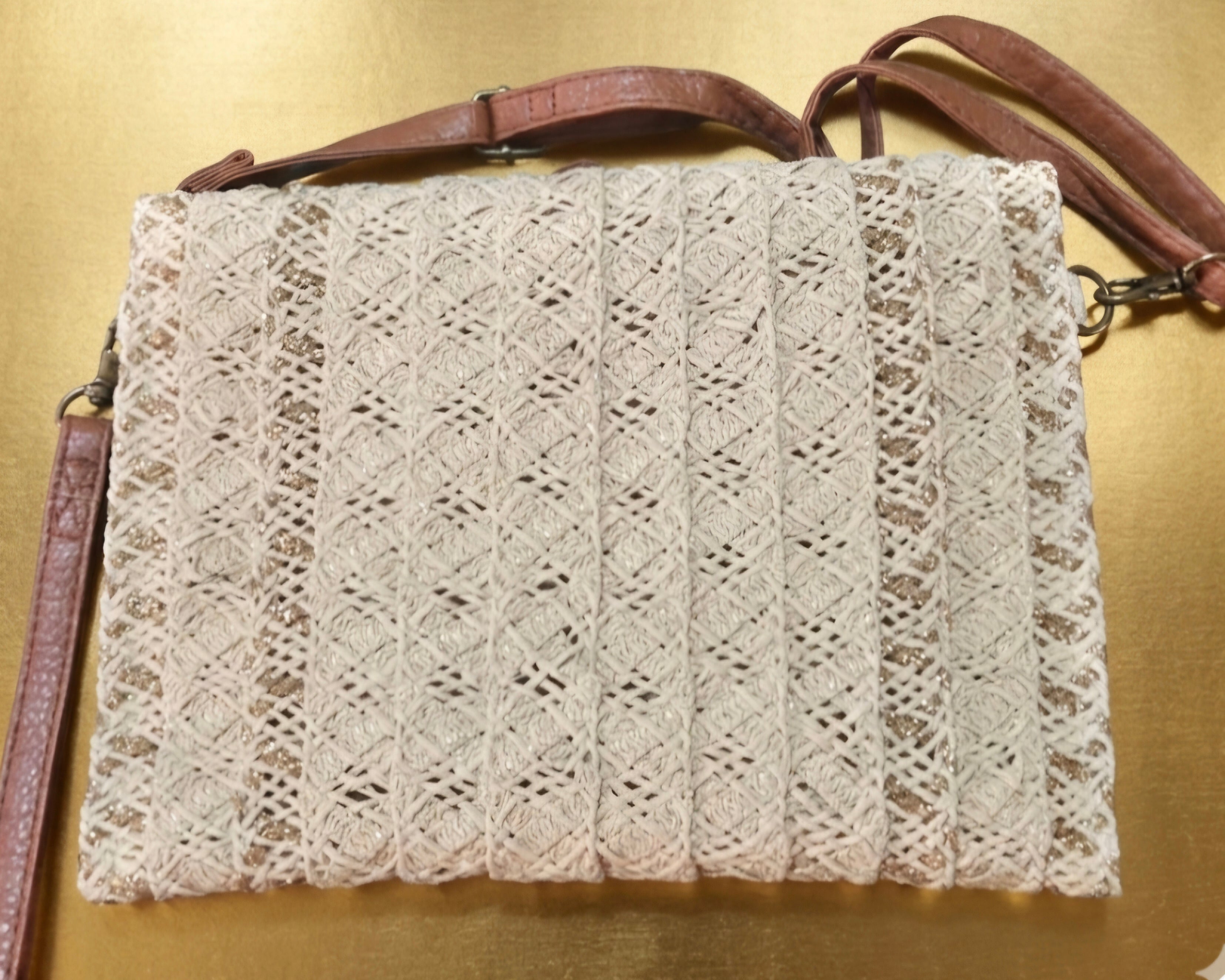 Bolso boho chic con detalles dorados y borlas decorativas.